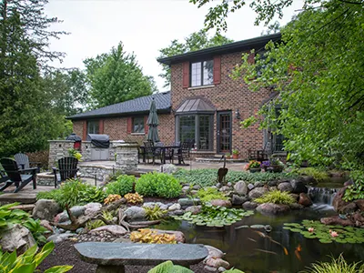 Cozy backyard patio with pond and garden.