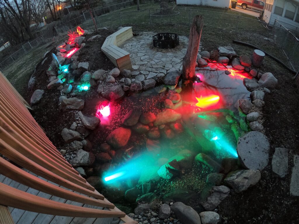 Backyard pond with colorful illuminated stones